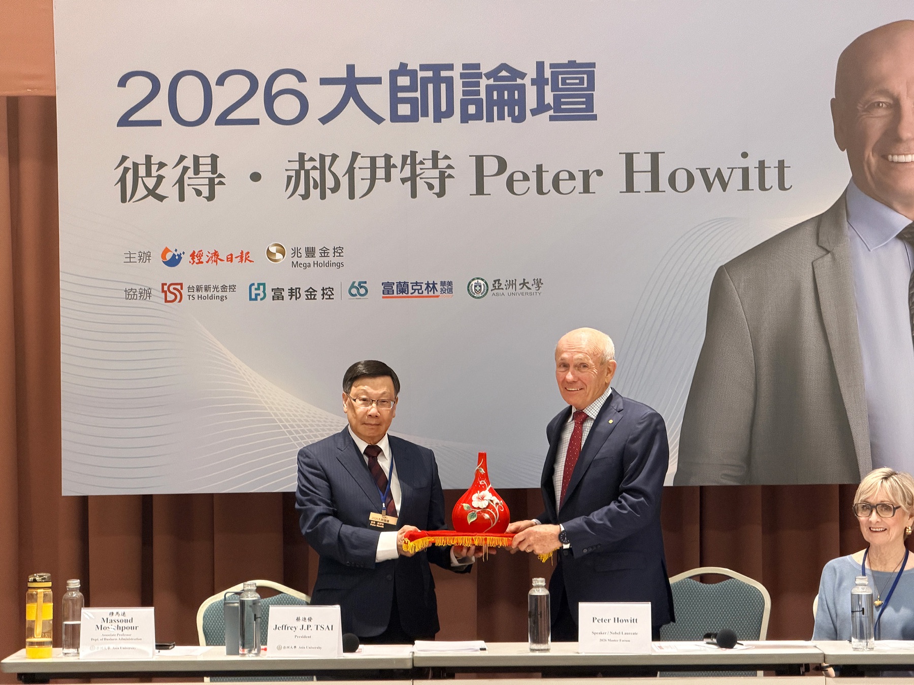 Asia University President Jeffrey J. P. Tsai presenting a commemorative gift to Professor Peter Howitt